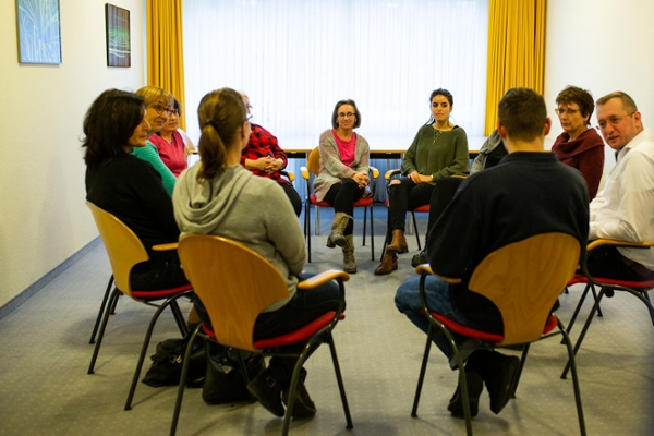 Personengruppe im Kreis sitzend Personengruppe im Kreis sitzend